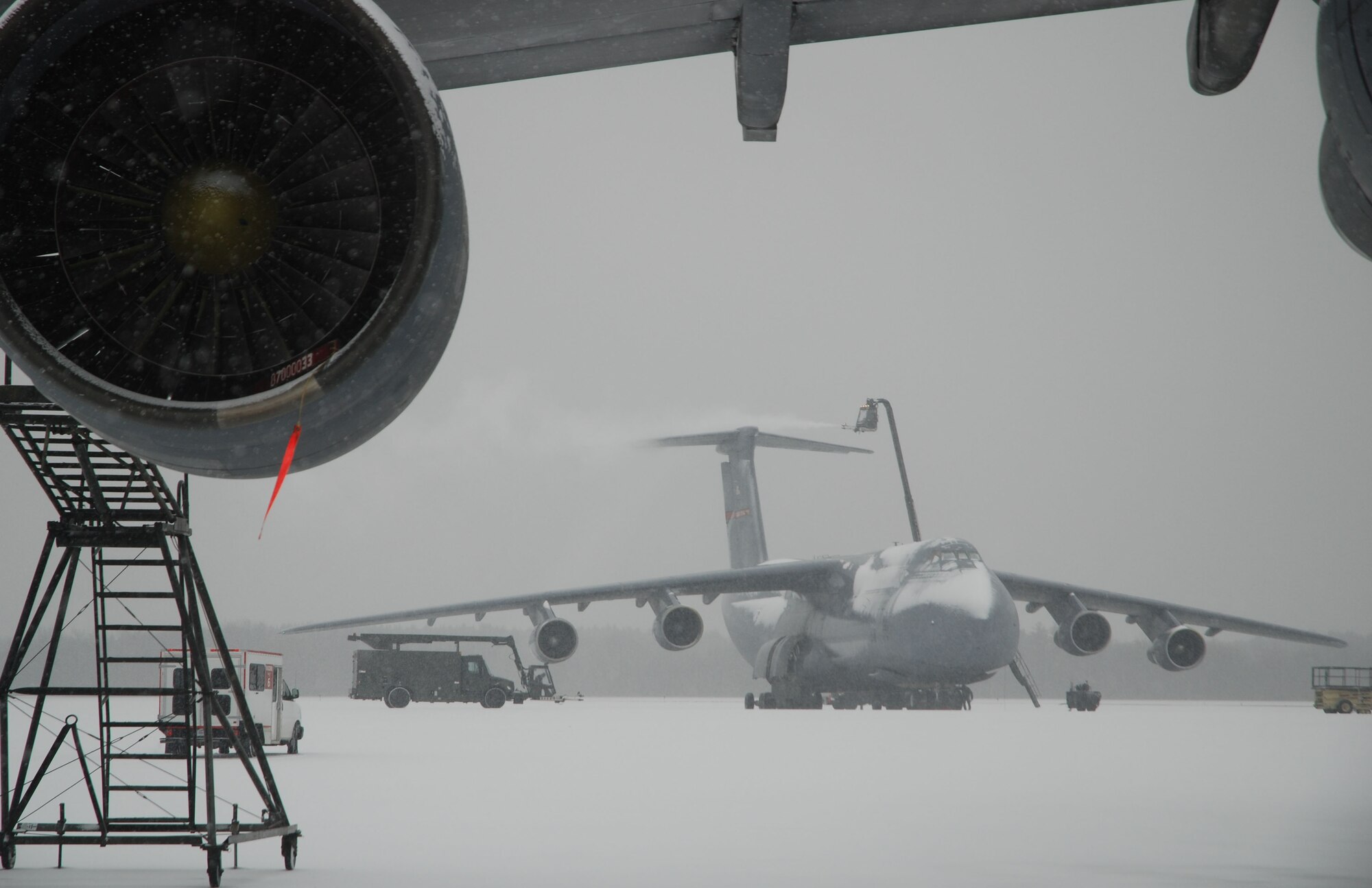 A maintenance crew de-ices a 439th Airlift Wing C-5 during a snowstorm at Westover Jan. 28. Patriot Wing maintainers work day and night to keep Westover's fleet of 16 C-5B airlifters ready to support worldwide mobility taskings. (US Air Force photo/Tech. Sgt. Andrew Biscoe)
