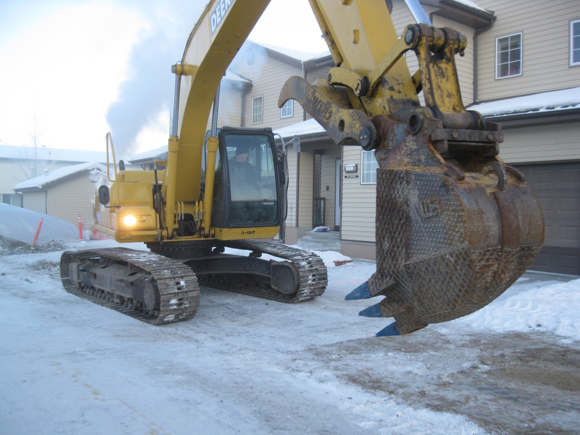 Senior Airman Caleb Hurley operates the escavator with tempratures reaching 44 degrees below zero Jan 13, 2010, Eielson Air Force Base. The construction on Kodiak  street allowed families to move back in their homes after a leak in a pipeline caused the homes to lose heat. He is from the 354th Civil Engineer Squadron snow barn flight. (U.S. Air Force photo/Tech. Sgt. Manuel Lara)