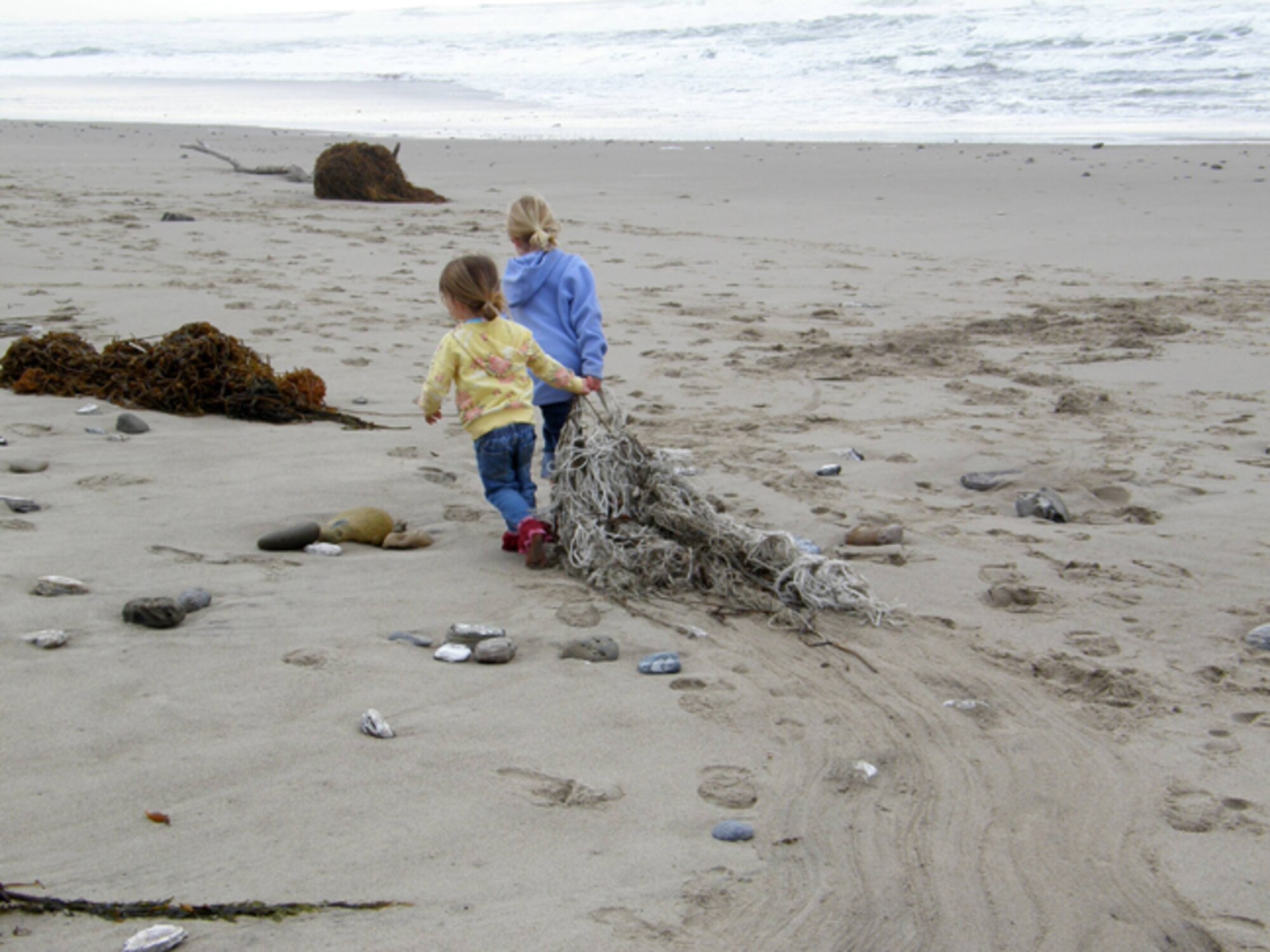 VANDENBERG AIR FORCE BASE, Calif. -- Braedyn Stricker and Bailey Stricker, of the Vandenberg Home-school Inclusive Partnership, work together to remove a tangled rope from Wall Beach here Monday, Jan. 25, 2010. The team of Vandenberg home-schoolers removed trash and nine tires from the beach. (Courtesy photo/Vandenberg Home-school Inclusive Partnership)