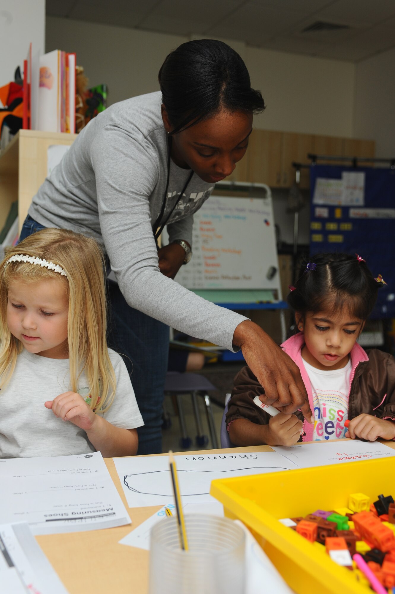 Capt. Shannon Walker, 379th Expeditionary Force Support Squadron manpower organization chief, checks a kindergartener?s paper, at a host-nation American school, for errors at a non-disclosed Southwest Asia location Jan. 27, 2010. The event was sponsored by the Company Grade Officers Council. (U.S. Air Force photo by Senior Airman Kasey Zickmund)[RELEASED]