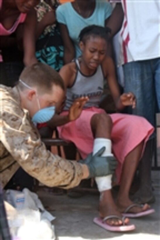 U.S. Navy Petty Officer 2nd Class Caleb Medders, a hospital corpsman assigned to Battalion Landing Team, 1st Battalion, 9th Marine Regiment, treats a Haitian woman during an assessment at Grand Saline, Haiti, on Jan. 25, 2010.  Marines and sailors are in the town to conduct a survey to determine what can be done to assist earthquake victims.  