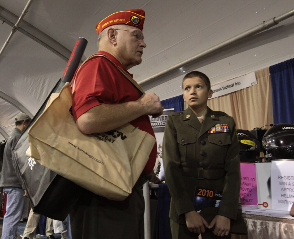 Bert Plannette, a representative, Marine Corps League Rogue Valley Detachment 386, strikes up a conversation with Young Marine Cpl. Ray Munoz, Temecula Valley Young Marine, during the 2010 Marine West Exposition, Camp Pendleton, Jan. 27.  Plannette and Munoz saw first hand, displays of advanced military vehicles, emergency medical equipment and many more defense gadgets.