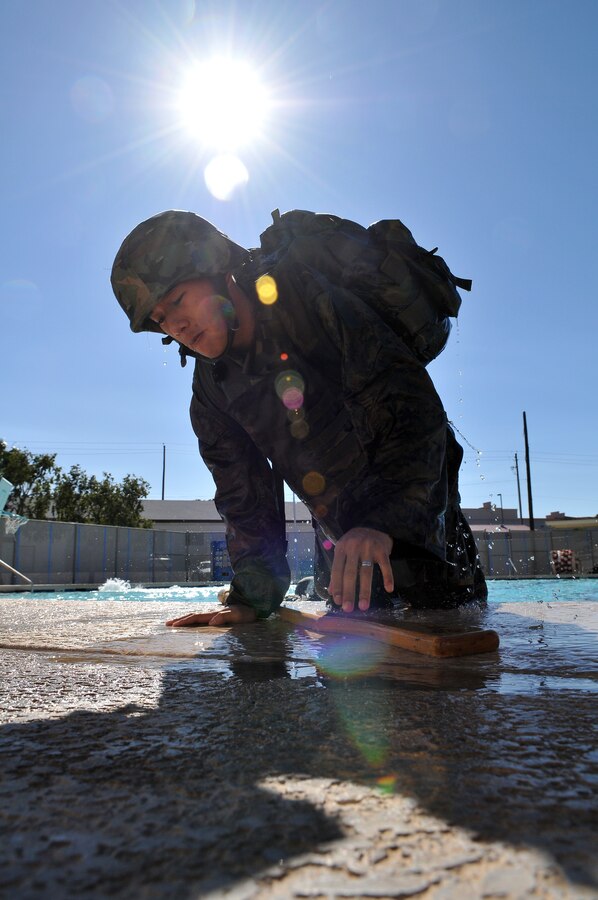 Cpl. Yao Lee, Installation Personnel Administration Center pay administration clerk, hauls himself out of the Oasis Pool at the Marine Corps Air Station in Yuma, Ariz., during his Marine Combat Water Survival Course qualification, Jan. 28, 2010. Seventeen Headquarters and Headquarters Squadron Marines braved the approximately 50 degree water to qualify for the initial level of swim qualification, while Lee and two other Marines continued to the third level of qualification. The third level requires Marines to enter the pool with a combat load and simulated rifle, swim 50 meters, and then tow a simulated casualty 25 meters through the water. Qualifications, which are usually held at Naval Air Facility El Centro, Calif., for Yuma Marines, have been held on station for approximately a month due to the expense of transporting Marines there. “I don’t think the training is as realistic here,” said Cpl. Nick Wolff, H&HS Marine combat water survival instructor, referring to Oasis Pool’s lack of a high dive. “But you’ve got to do what you’ve go to do to get the mission accomplished."