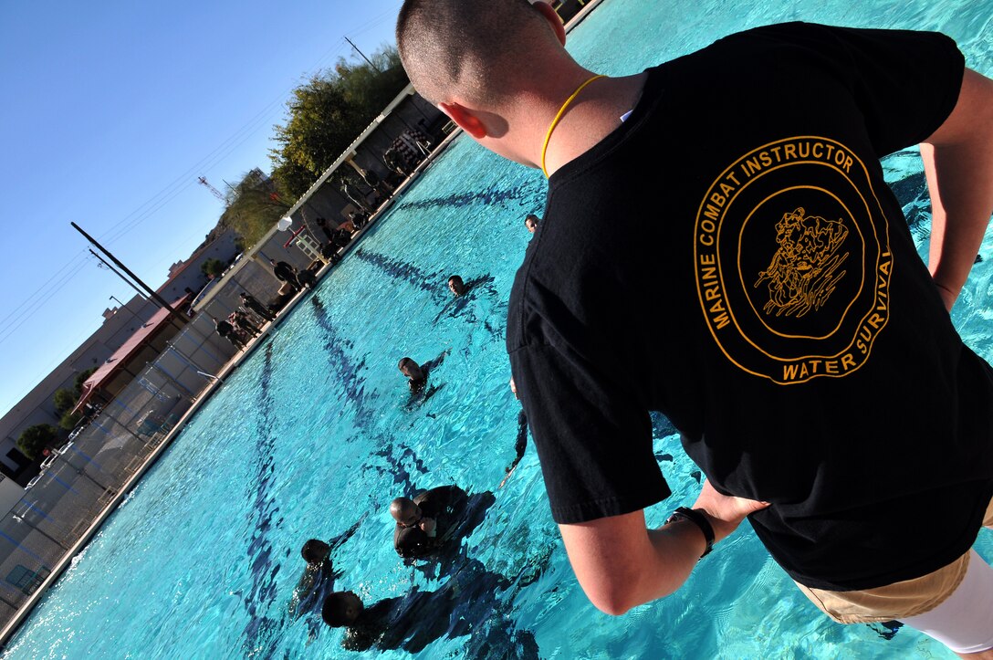 Cpl. Nick Wolff, Marine Combat Water Survival instructor, observes as Headquarters and Headquarters Squadron Marines tread water for the second portion of their initial level of swim qualification at the Oasis Pool at the Marine Corps Air Station in Yuma, Ariz., Jan. 28, 2010. Seventeen Marines braved the approximately 50 degree water to qualify for the initial level of swim qualification, which requires Marines to swim 25 meters in shallow water, perform water survival techniques for four minutes and then swim another 25 meters. Qualifications are usually held at Naval Air Facility El Centro, Calif., but have been held on station for approximately a month, due to the expense of transporting Marines there. “I don’t think the training is as realistic here,” said Wolff, referring to Oasis Pool’s lack of a high dive. “But you’ve got to do what you’ve go to do to get the mission accomplished.”