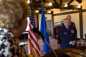 Lieutenant Col. Thomas G. Marcoux, (ret.) former 316 Wing Protocol senior duty officer, right, looks on as Janet Grammp, Fisher House director, left, congratulates him on the occasion of his retirement during ceremonies held at the The Courses at Andrews Jan. 22, 2010. Colonel Marcoux retired with more than 40 years of military service. (U.S. Air Force photo by Bobby Jones)