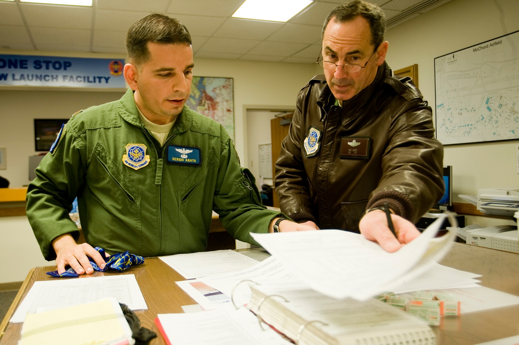 Gen. Raymond E. Johns, Jr., Air Mobility Command commander and Maj. Sergio Anaya, 7th Airlift Squadron, attend a pre-flight mission briefing at McChord's One Stop aircrew launching facility here Monday. (U.S. Air Force Photo/Abner Guzman)