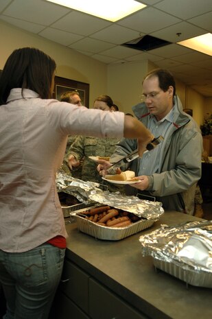 Cadet Dominique Lewis serves up a hotdog to Jon Kidder during a free lunch here for members of the 437th Aerial Port Squadron Jan. 29. The commandant of cadets for Charleston Southern University's Air Force Reserve Officer Training Corps Detachment 772 coordinated the event through Charleston AFB leadership to show appreciation to the members of the aerial port for their hard work during the Haiti relief effort, having moved to 12-hour shifts to keep up 24-hour operations. Cadet Lewis is a student at CSU and Mr. Kidder is the Air Force Smart Operations for the 21st Century program manager for the 437 APS. (U.S. Air Force photo/Airman 1st Class Lauren Main)
