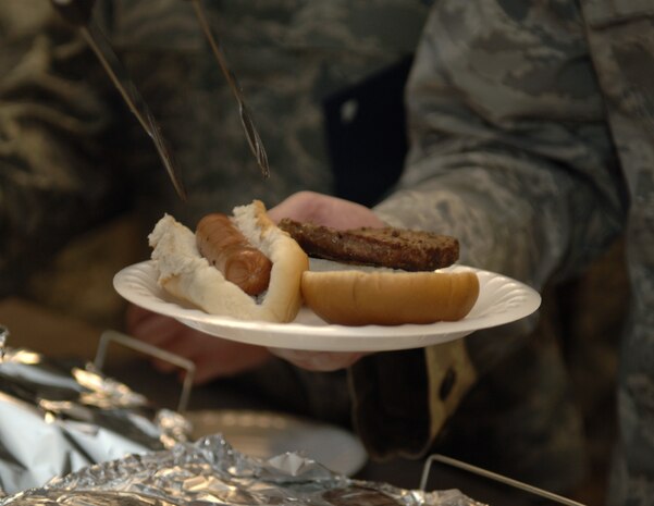 Hotdogs and hamburgers are served to members of the 437th Aerial Port Squadron here during an free lunch Jan. 29. The lunch was hosted by Air Force Reserve Officer Training Corps Detachment 772 cadets with Charleston Southern University to support the squadron's Airmen as they continue their work for Haiti relief efforts. The Airmen of the squadron have shipped more than 1,300 tons of cargo to Haiti, working around the clock on 12-hour shifts. (U.S. Air Force photo/Airman 1st Class Lauren Main)