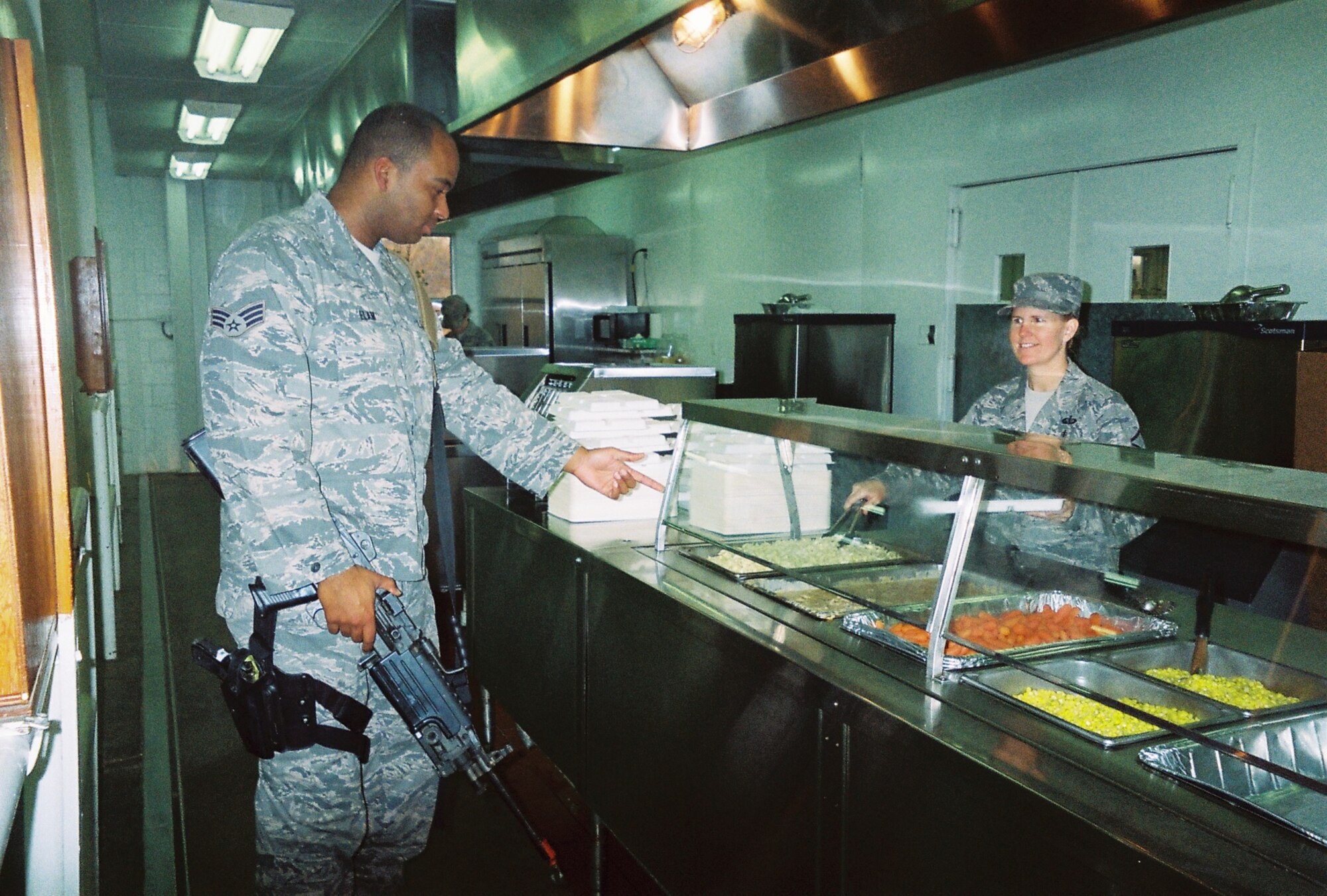 934th Security Forces Squadron members were welcomed with friendly smiles and plentiful food served up by 940th Wing Services Flight Reservists during Patriot Defender combat training at Ft. Wolters, Texas, in January. The team of eight SVF members from Beale Air Force Base, Calif., dished up nearly 7,400 hot meals during their 15-day deployment in January 2010. Master Sergeant Marielinda Pierce greets a customer coming in for a hot meal after a day of training.  (U.S. Air Force Photo/Master Sgt. Barbra Mateus)