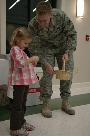 Lily Yengo and Tech. Sgt. Ricky Smith draw names from a basket to determine the door prize winners at the Quarterly Spouse Appreciation Dinner for spouses of deployed members hosted by the base chapel and Airman and Family Readiness Center Jan. 28. The event was the first of many appreciation dinners planned for the year. Lily is the daughter of Capt. Chris Yengo, a pilot with the 14th Airlift Squadron, who is currently deployed to the Middle East and Sergeant Smith is with the AAFRC. (U.S. Air Force Photo/Airman 1st Class Lauren Main)