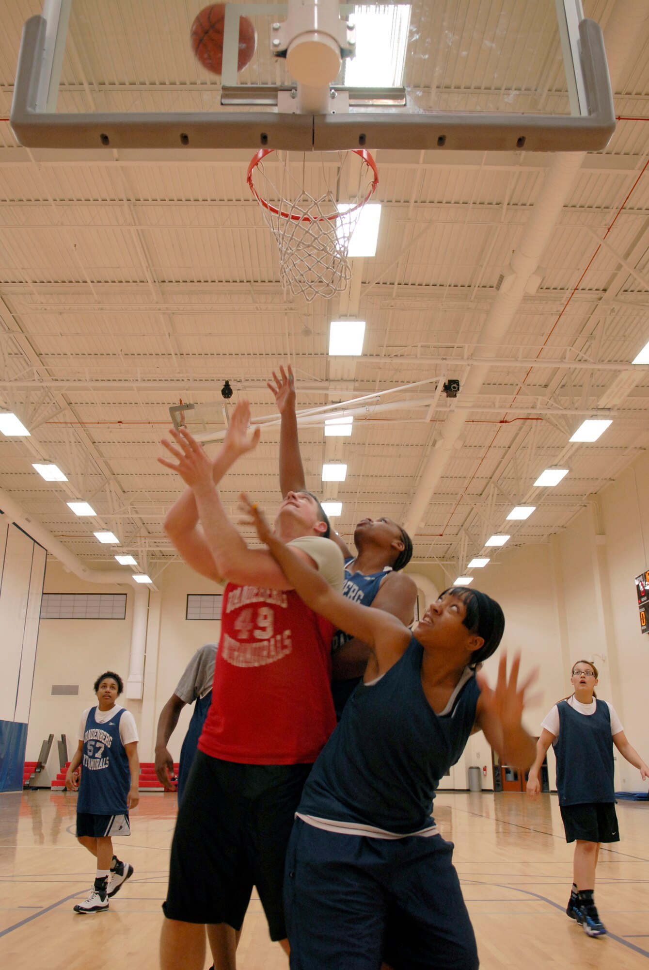 VANDENBERG AIR FORCE BASE, Calif. -- Paul Vignola, Lillian Street and Sharita James fight for position to gain control of the ball during an intramural basketball game at the Vandenberg Fitness Center here Thursday, Jan. 28, 2010. The 30th Operations Group team battled against the Lady Hawks, winning 57-23.   (U.S. Air Force photo/Senior Airman Andrew Satran) 

 
 