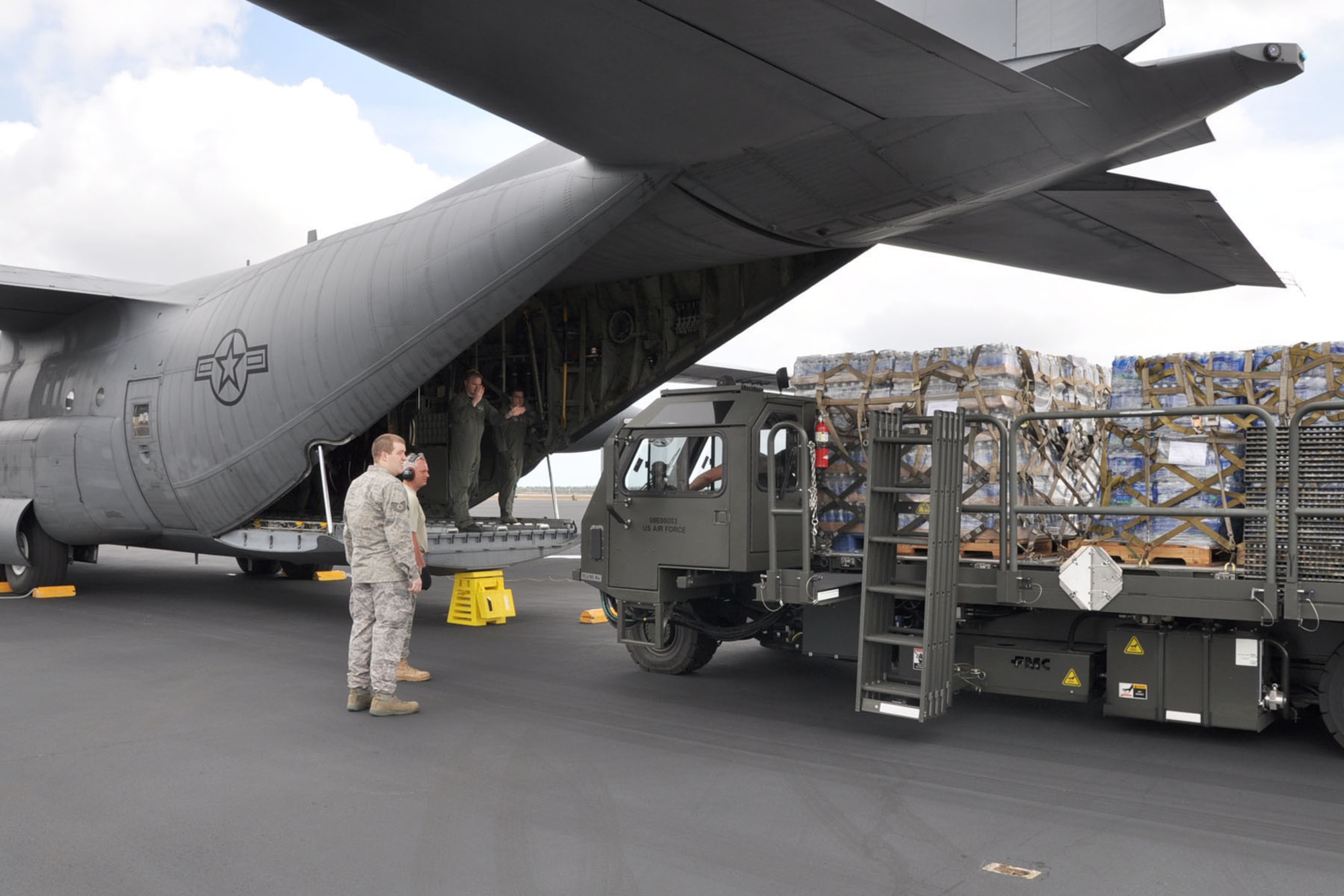 HOMESTEAD AIR RESERVE BASE, Florida -- U.S. Air Force Reserve Master Sgt. Dan Marhulik, a loadmaster assigned to the 910th Airlift Wing, directs a cargo handling vehicle towards the rear of a C-130H Hercules cargo aircraft on the flightline here, January 21. The vehicle is carrying 18,400 pounds of food and water that the aircraft, based at Youngstown Air Reserve Station, Ohio, will carry to San Isidiro Air Base, Dominican Republic, where it will be trucked across the island to Port-au Prince, Haiti as part of the massive international effort to provide relief to the people of the Caribbean island nation in the aftermath of a devastating January 12 earthquake. U.S. Air Force photo by Master Sgt. Bob Barko Jr.