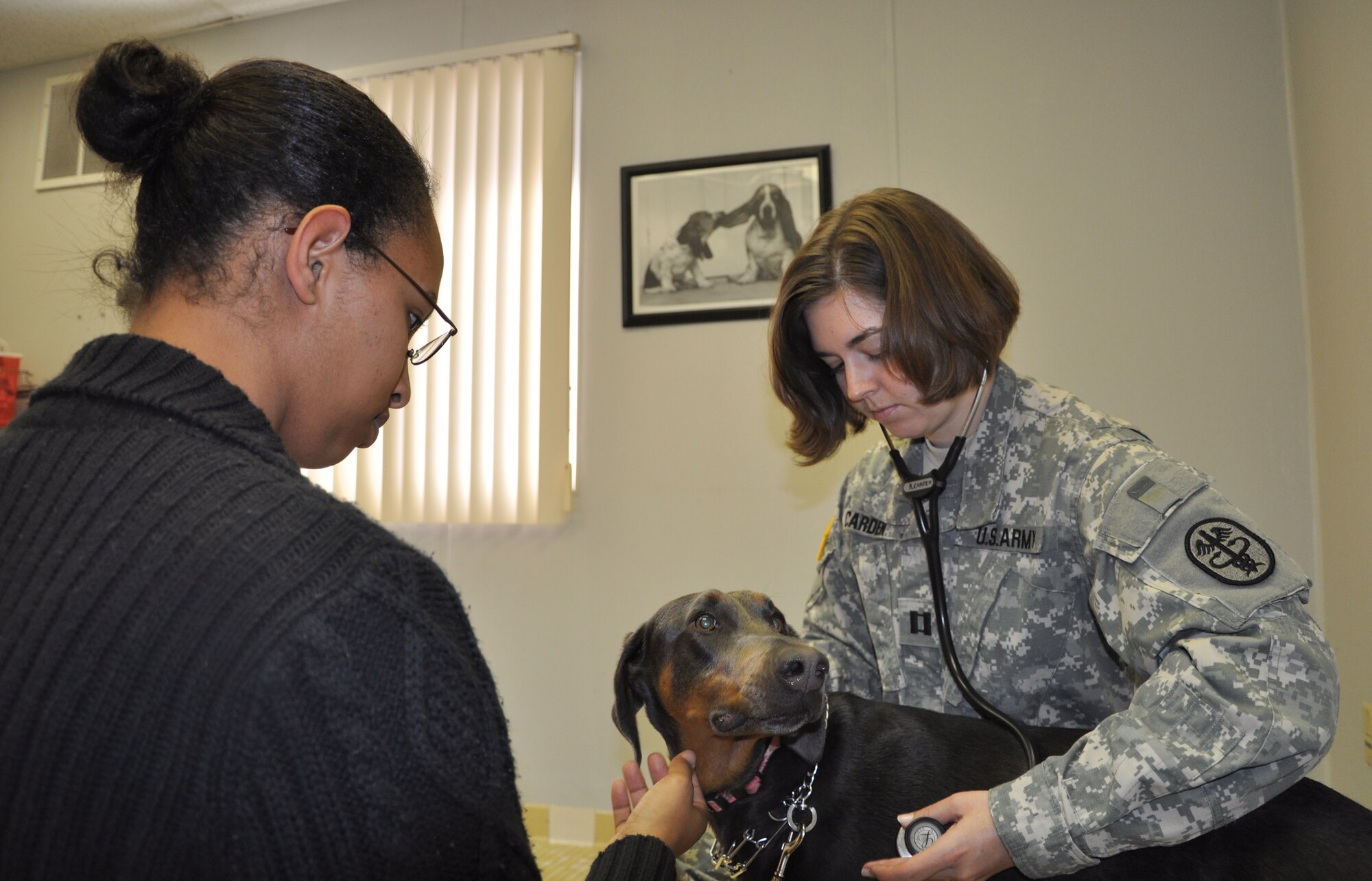 LAUGHLIN AIR FORCE BASE, Texas – Claire Gaddis watches as Army Capt. Rebecca Carden, veterinarian, listens to the heart of the couple’s Doberman pinscher, Mandy. Gaddis brought Mandy to the Veterinarian Clinic in Building 25 here Jan. 21 for a check-up and vaccinations. (U.S. Air Force photo by Tech. Sgt. Charlie Miller)