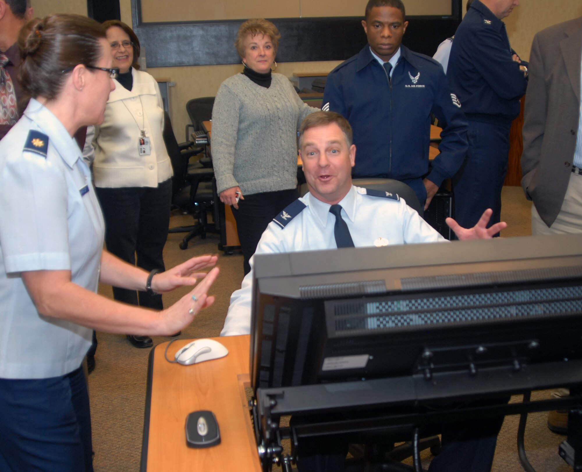Maj. Susan Wheately, DPB, demonstrates some of the features on the new tables in the selection board room for Col. David Zeh (seated), ARPC vice commander. ARPC officials unveiled the 53 new automated tables and touchscreen monitors Jan. 25. (U.S. Air Force photo/Dwayne Beuthel) 