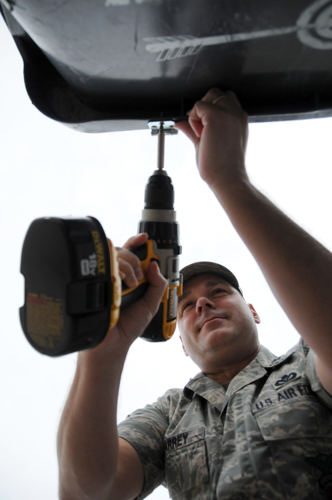 Col. David Maharrey, 96th Civil Engineer Group commander, installs "bear latches" on garbage cans in the Poquito Bayou housing area, Jan. 29 at Eglin Air Force Base. Volunteers from the 96th CEG are installing the latches on every garbage can in housing in hopes of discouraging bears from using the trash as a food source that will keep them coming back. In addition to the latches, the volunteers are also going door-to-door distributing information on methods to prevent bears from returning. All housing residents should have the latches installed within the next few weeks. (U.S. Air Force photo/ Airman 1st Class Anthony Jennings)