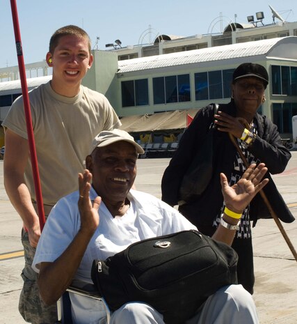Airman 1st Class Aaron Mealhow escorts evacuees Fritz Gabriel and his wife Mary to a C-17 at Aeroport International Toussaint Louverture in Port-au-Prince, Haiti, Jan. 28. Airman Mealhow is a member of the 62nd Aerial Port Squadron from McChord Air Force Base, Wash. The Air Force flew the Gabriels and other evacuees to Orlando Sanford International Airport in Florida. (U.S. Air Force photo/Staff Sgt. Barry Loo)