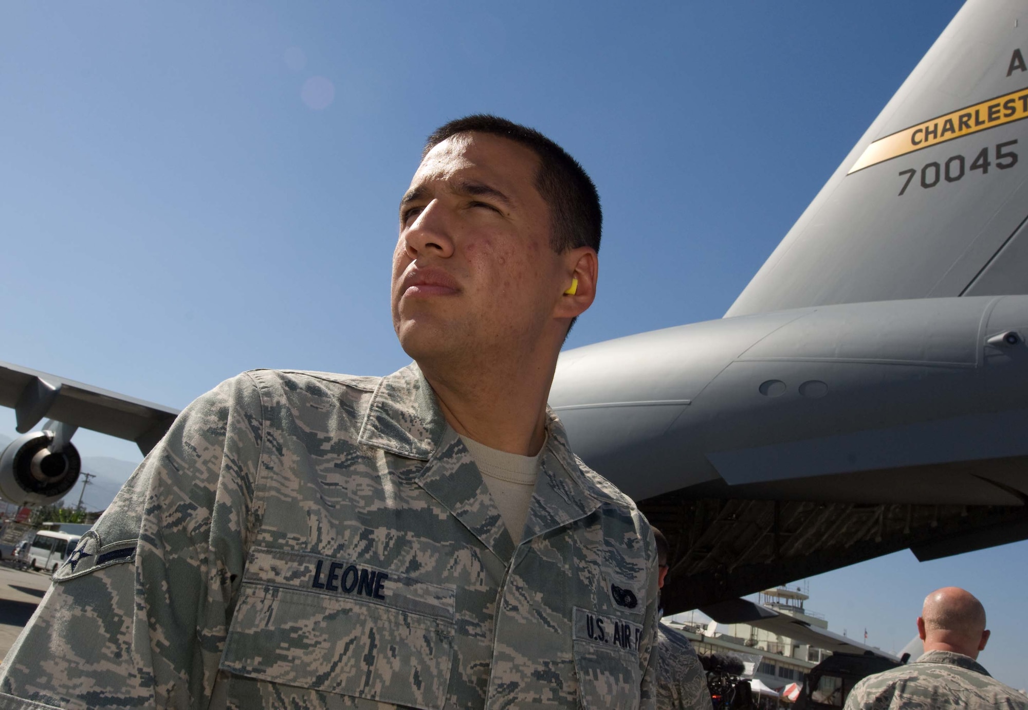 Airman Sam Leone guards a C-17 at Aeroport International Toussaint Louverture in Port-au-Prince, Haiti, Jan. 28.  Airman Leone is a member of the 628th Security Forces Squadron from Charleston Air Force Base, S.C. Joint Team Charleston has flown humanitarian missions to Haiti around the clock since the relief effort began. (U.S. Air Force photo/Staff Sgt. Barry Loo)