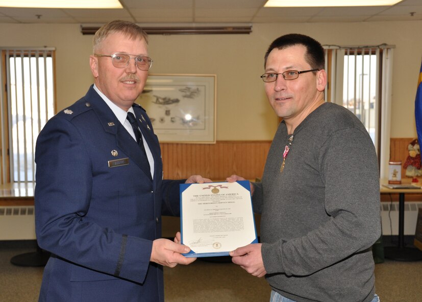 Tech. Sgt. Dustin Lee, 934th Services Squadron, receives the Meritorious Service Medal citation at his retirement ceremony Jan. 11 from Lt. Col. Neal Landeen, 934th SVS commander. (Air Force Photos/Senior Airman Noah Johnson)
