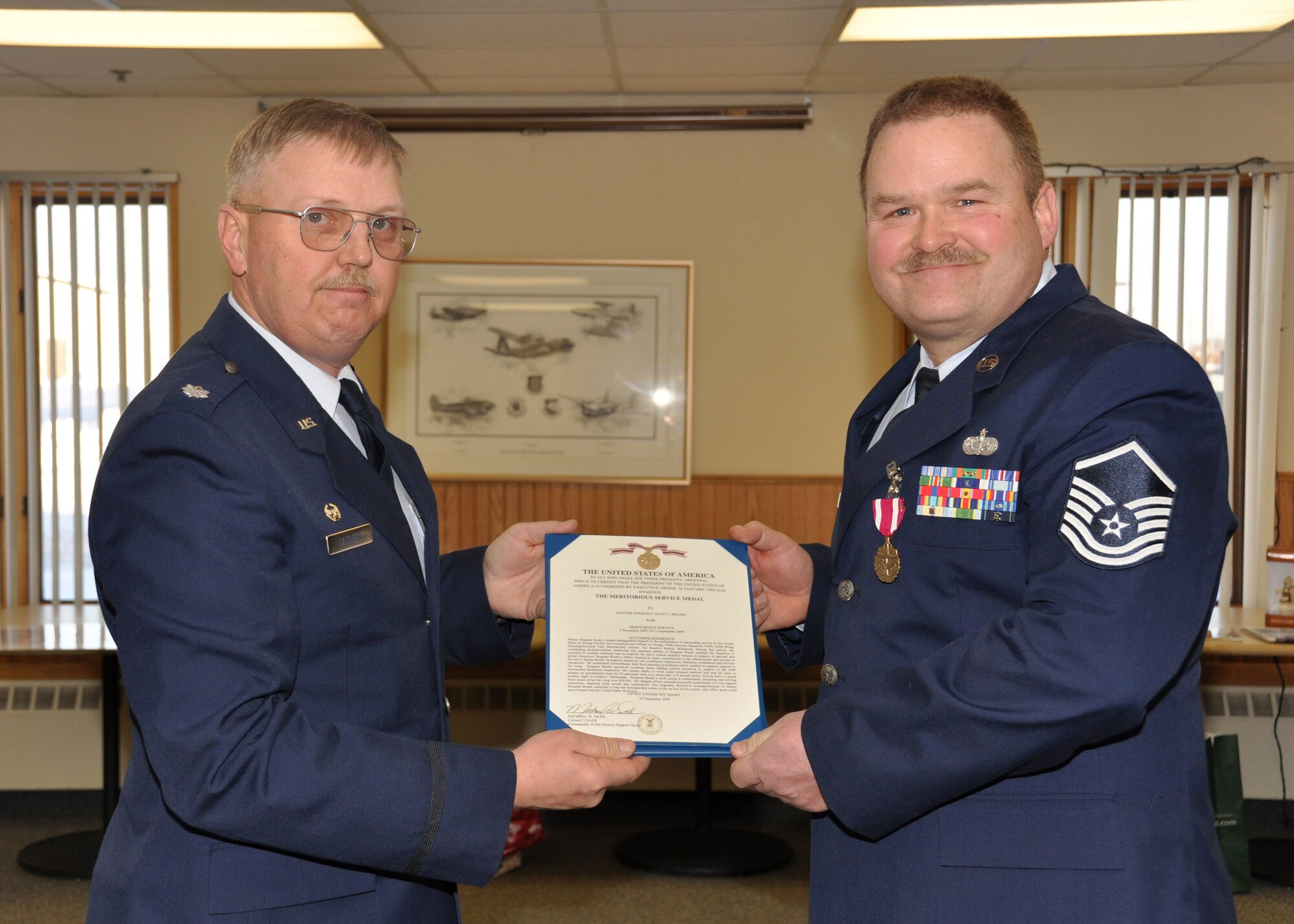 Master Sgt. Scott Braski, 934th Services Squadron, receives the Meritorious Service Medal citation at his retirement ceremony Jan. 11 from Lt. Col. Neal Landeen, 934th SVS commander. (Air Force Photos/Senior Airman Noah Johnson)