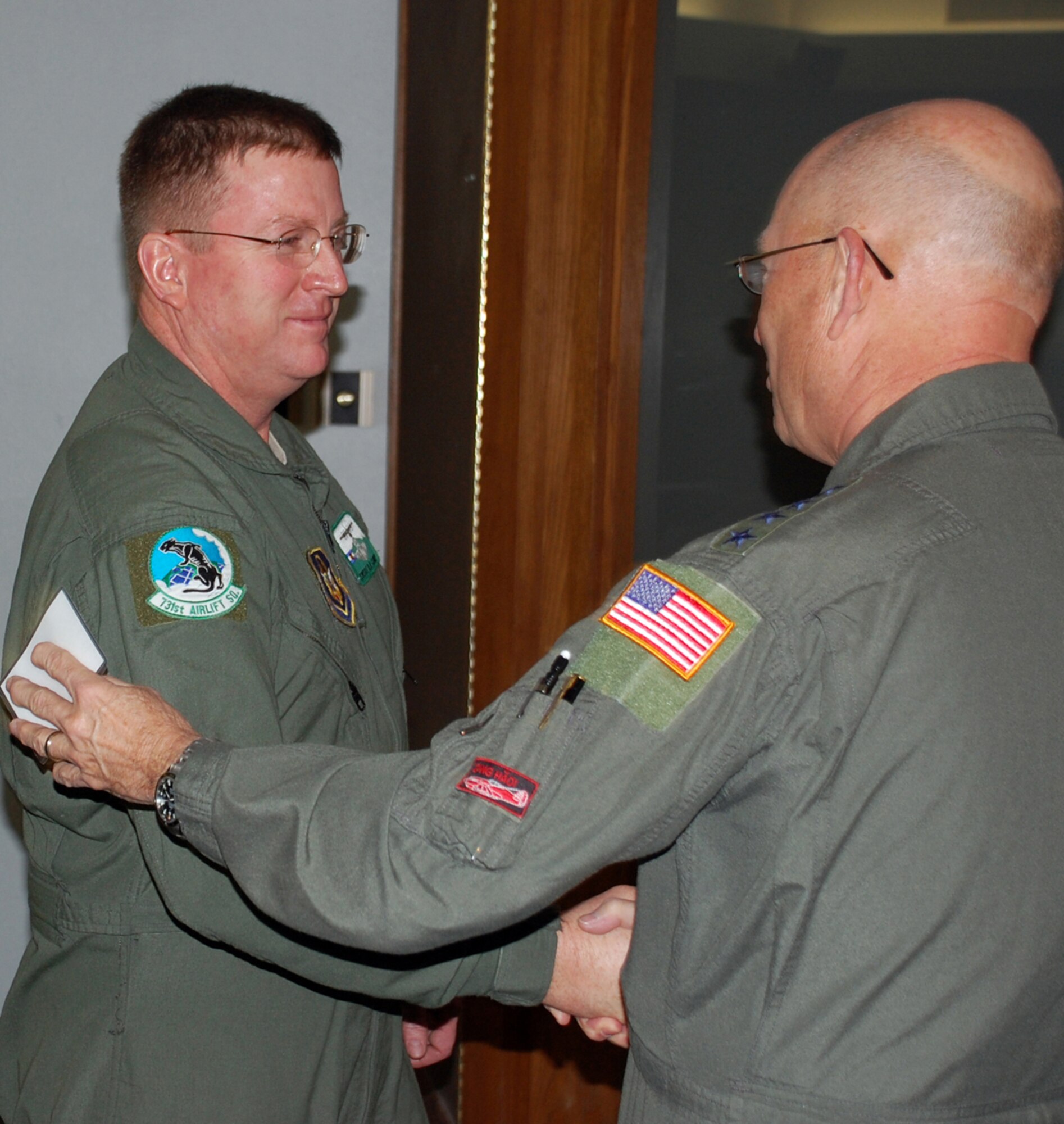 Gen. Victor Renuart, right,commander, U.S. Northern Command, congratulates Senior Master Sgt. Dave Carey after performing the oath of enlistment, Jan. 28 here. Sergeant Carey, a Reserve flight engineer with the 731st Airlift Squadron, asked the general to perform his final reenlistment, which will take him to 38-years in the Air Force. "This is one of the top ten moments of my career,” said Sergeant Carey.