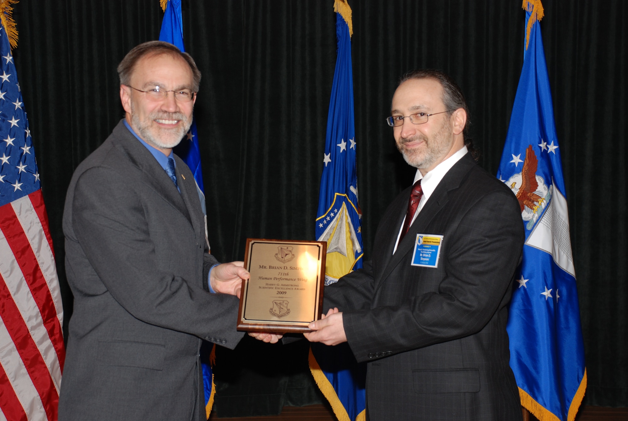 Mr. Thomas Wells (left), director of the Air Force Research Laboratory’s 711th Human Performance Wing (711 HPW), presents the Harry G. Armstrong Award to 2009 winner Mr. Brian Simpson, engineering research psychologist with the Human Effectiveness Directorate’s Warfighter Interface Division, Battlespace Acoustics Branch,  January 22 at the HPW’s annual awards luncheon. (Photo by Chris Gulliford, 711 HPW)