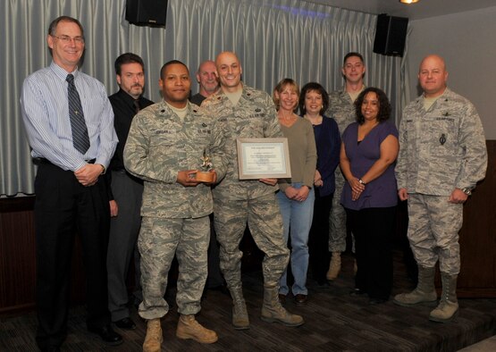 Col. Jim Jennings (right) 21st Space Wing vice commander, presented the October Golden Knight award for teamwork between the 21st Comptroller Squadron and the 21st Contracting Squadron for end of year closeout purchasing. (Air Force photo by Rob Bussard)