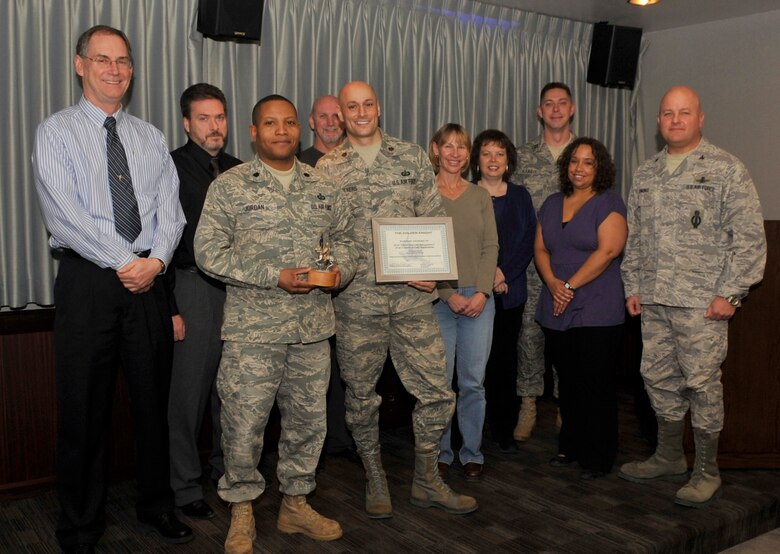 Col. Jim Jennings (right) 21st Space Wing vice commander, presented the October Golden Knight award for teamwork between the 21st Comptroller Squadron and the 21st Contracting Squadron for end of year closeout purchasing. (Air Force photo by Rob Bussard)