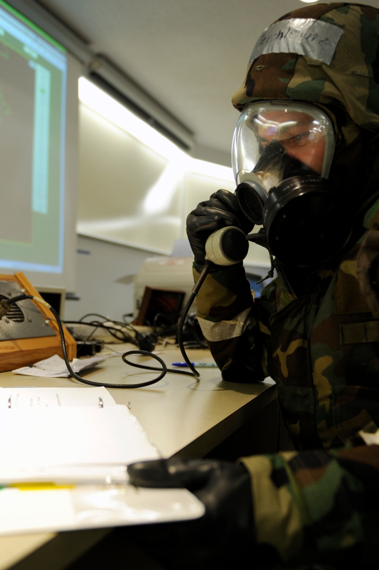 SCOTT AIR FORCE BASE, Ill. – Senior Airman Paul Merchletz, 133rd Airlift Wing Command Post controller, makes an announcement through his gas mask January 25, 2010, over the base public address system during the Operational Readiness Exercise held at Volk Field Combat Readiness and Training Center, Wis. The public address system is one of a couple different methods used to make exercise participants aware of changes in the alarm conditions and mission oriented protective posture 4. (U.S. Air Force photo/Senior Airman Wesley Farnsworth) 