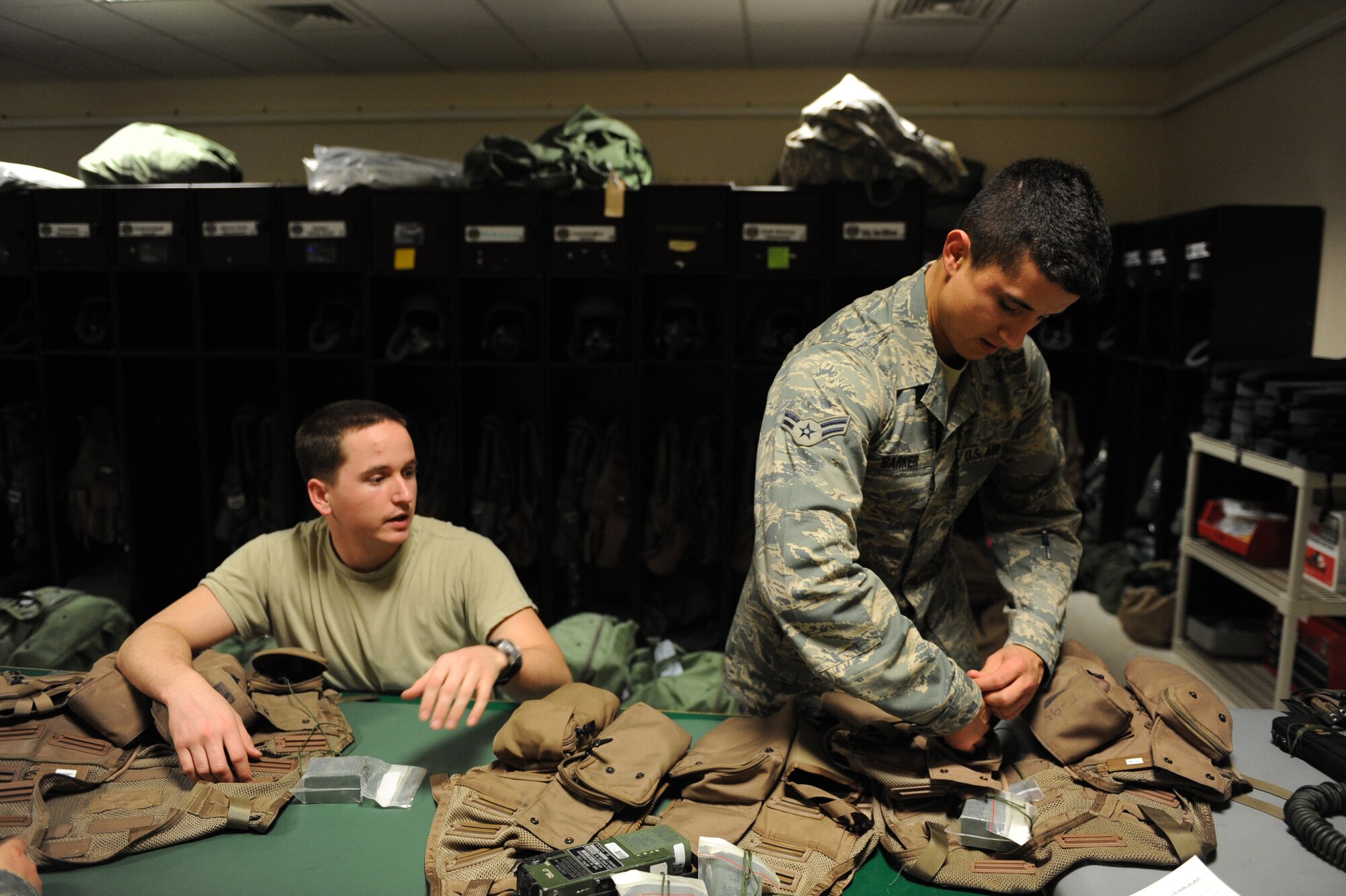 Airman Brandon Locke (left) and Airman 1st Class Stephen Barker, aircrew flight equipment journeymen assigned to the 37th Expeditionary Bomb Squadron, re-equip combat survival vests Jan. 24, 2010, in Southwest Asia. (U.S. Air Force photo/Staff Sgt. Manuel J. Martinez\Released)