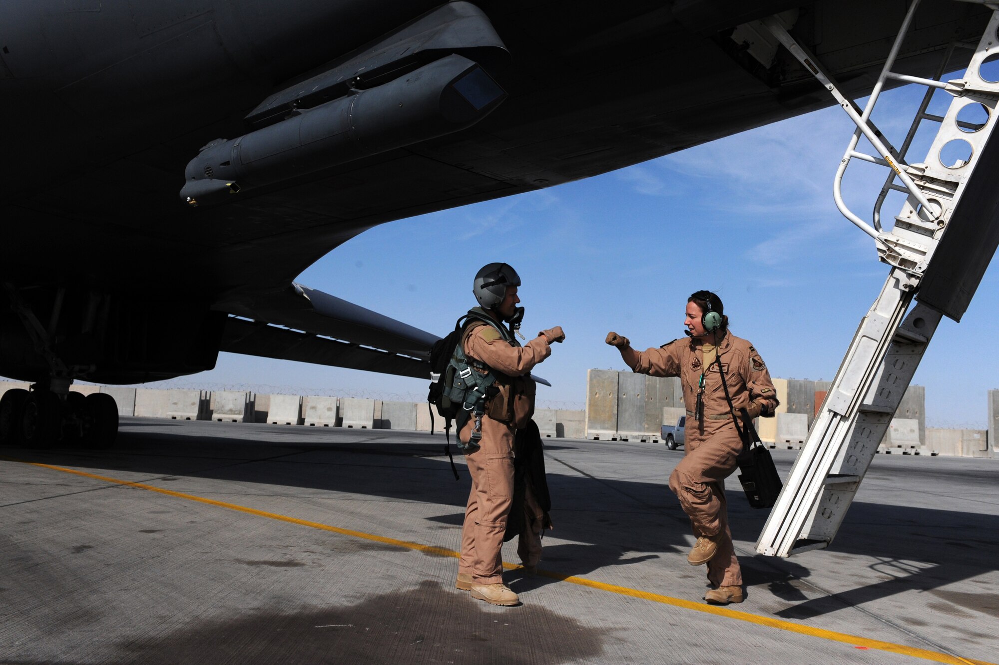 Lt. Col. John ''Oasis'' Martin, B-1B Lancer pilot, and Capt. Tara Hart, a B-1B weapon system officer, both assigned to the 37th Expeditionary Bomb Squadron, exchange a good-luck gesture before boarding a B-1B bomber Jan. 23, 2010, in Southwest Asia. Lt. Col. Martin and his flight crew are stationed at Ellsworth Air Force Base and this was the last mission of their six-month deployment.  (U.S. Air Force photo/Staff Sgt. Manuel J. Martinez/Released)