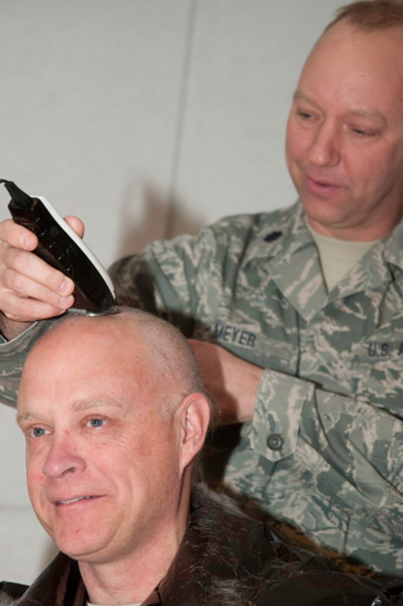 After receiving the grade of outstanding after a recent inspection, as promised, Colonel Andy Halter, 139th maintenance group commander, surrendered his hair on stage, January 11, 2010. Capt. Orth and Lt.Col. Gordon Meyer, 139th Maintenance, were happy to oblige the group commander. (U.S. Air Force photo by Master Sgt. Shannon Bond)