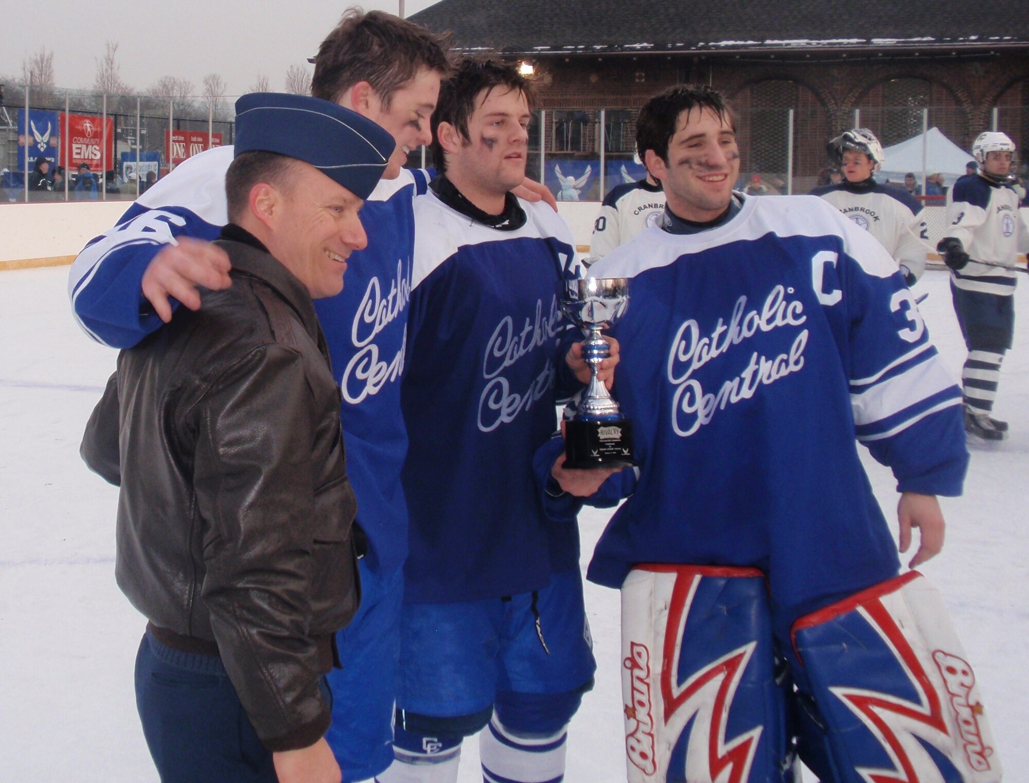 Lt. Col. Todd Weyerstrass presents the Detroit Catholic Central team captains the Great American Rivalry Series Champion trophy. (U.S. Air Force photo/ Tech Sgt. Michael Lionberger)