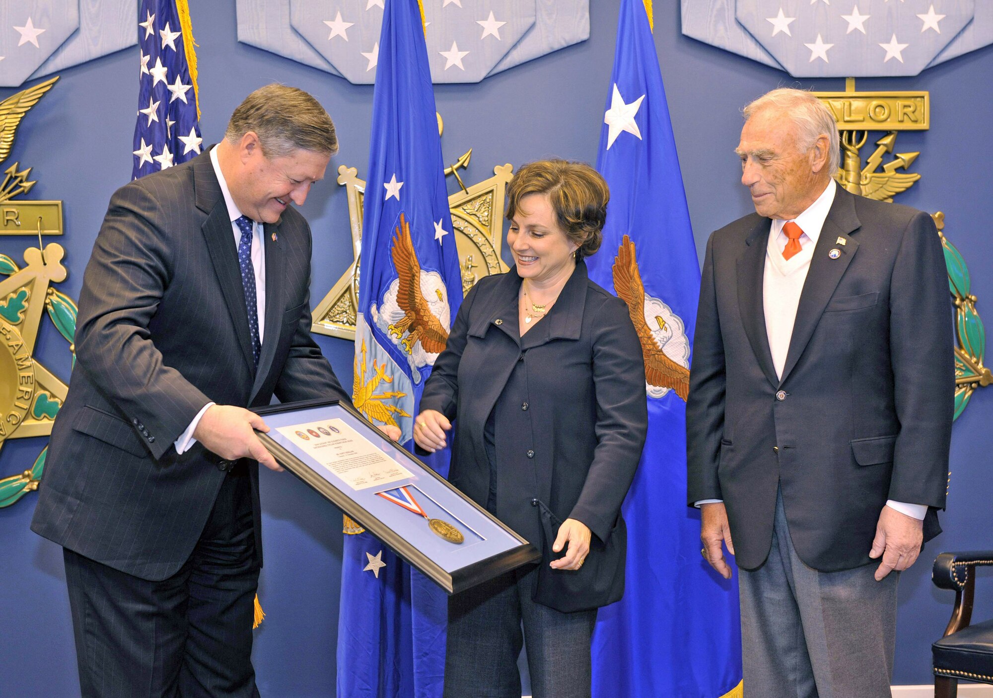 Secretary of the Air Force Michael Donley (left) presents a citation and medal to Nancy Berglass while Arnold Fisher looks on during a ceremony to present her the Zachary and Elizabeth Fisher Distinguished Civilian Humanitarian Award at the Pentagon's Hall of Heroes Jan. 28, 2010. The multidepartmental award was established in 1996 and is presented to those exemplifying personal qualities of patriotism, generosity, and selfless dedication to improving the quality of life of members of the armed forces of the United States. (U.S. Air Force photo/Jim Varhegyi)