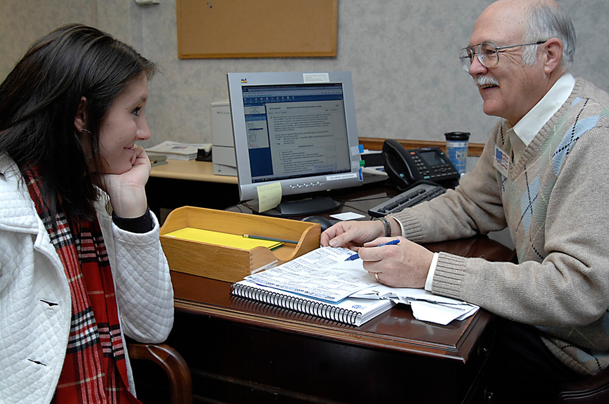 Mike Werner, a base tax center coordinator, helps Kelsey Kenney a Team McConnell family member, file her 2009 Federal Income Taxes, Jan. 28, 2010, at the McConnell Air Force Base, Kan. tax center, building 750. The president recently signed a Senate bill, Public Law 111-97, the 'Military Spouses Residency Relief Act,' which affords servicemembers an opportunity to maintain legal residency in their home states for tax and voting purposes.