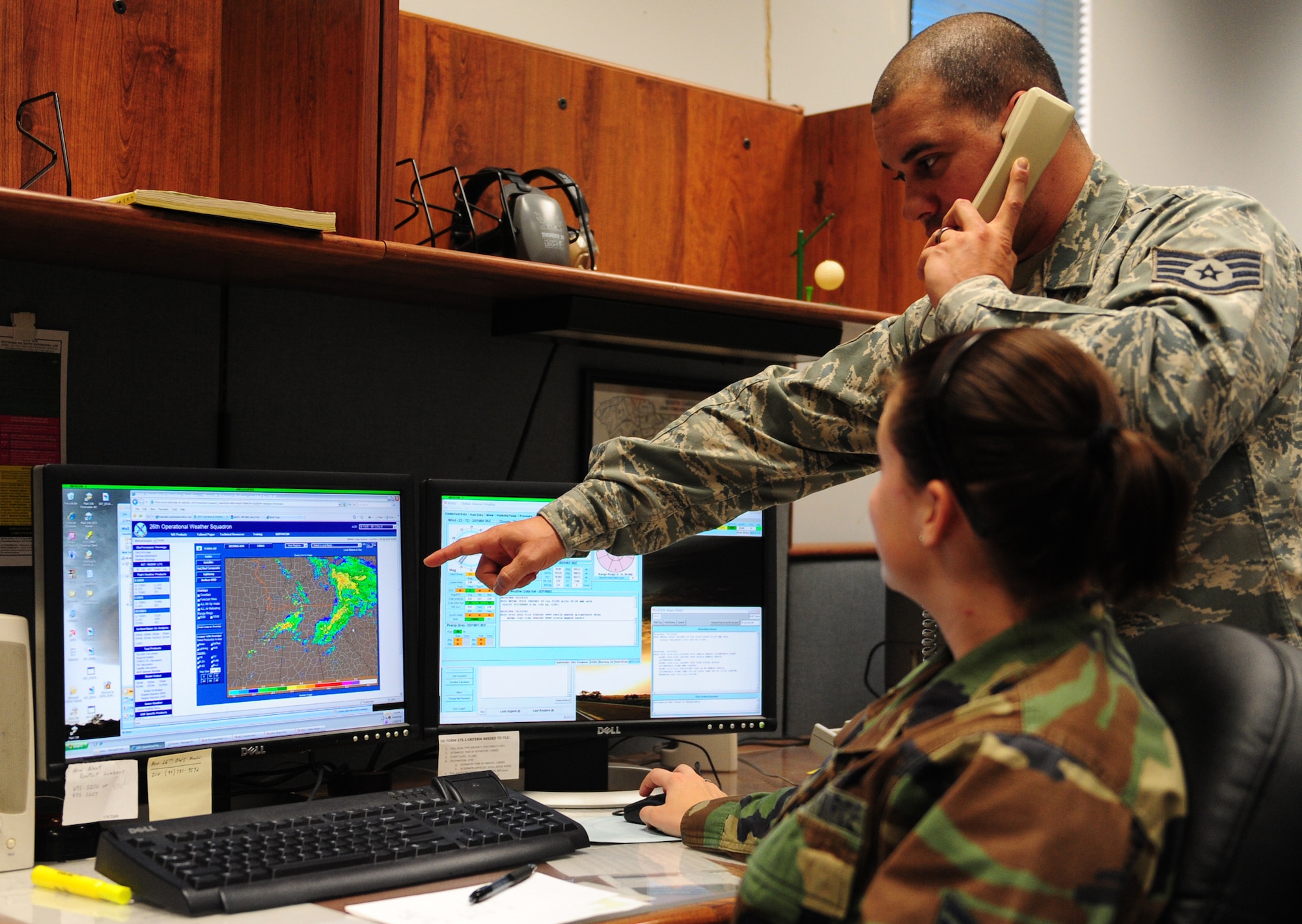 SHAW AIR FORCE BASE, S.C. -- Staff Sgt. Donald Blasini (standing), 20th Operations Support Squadron weather flight training NCO-in-charge, and Senior Airman Brittany Lawson, 20th OSS weather flight forecaster, consult with other forecasters concerning possible inclement weather Jan. 20.  The observations are used to produce weather forecasts and inclement weather advisories for Team Shaw.(U.S. Air Force photo/2nd Lt. Tony Richardson)