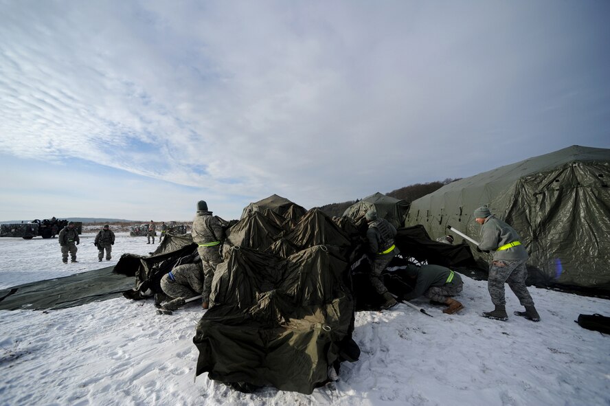 U.S. Air Force military members from the 435th Air Ground Operations Wing, Ramstein Air Base, Germany, construct tents at Flugplatz Bitburg, Germany, Jan. 27, 2010, in preparation of Ramstein's operational readiness inspection in September. The units are setting up bare-base operations as part of the dual-wing operational readiness exercise with the 86th Airlift Wing. This is the second of five operational readiness exercises. (U.S. Air Force photo by Staff Sgt. Sarayuth Pinthong)