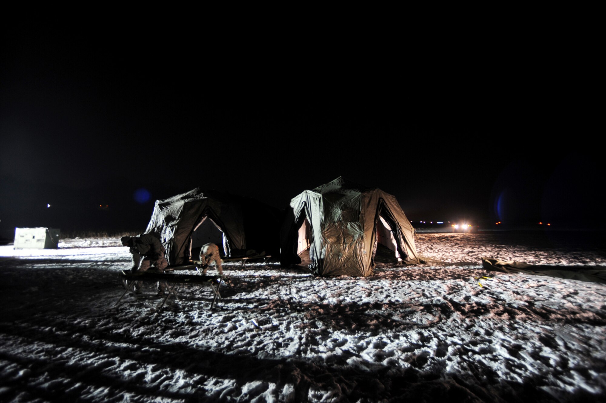 U.S. Air Force members set up tents after their arrival at Flugplatz Bitburg, Germany, Jan. 26, 2010, in preparation of Ramstein's operational readiness inspection in September. The units are setting up bare-base operations as part of the dual-wing operational readiness exercise with the 86th Airlift Wing. This is the second of five operational readiness exercises. (U.S. Air Force photo by Staff Sgt. Sarayuth Pinthong)