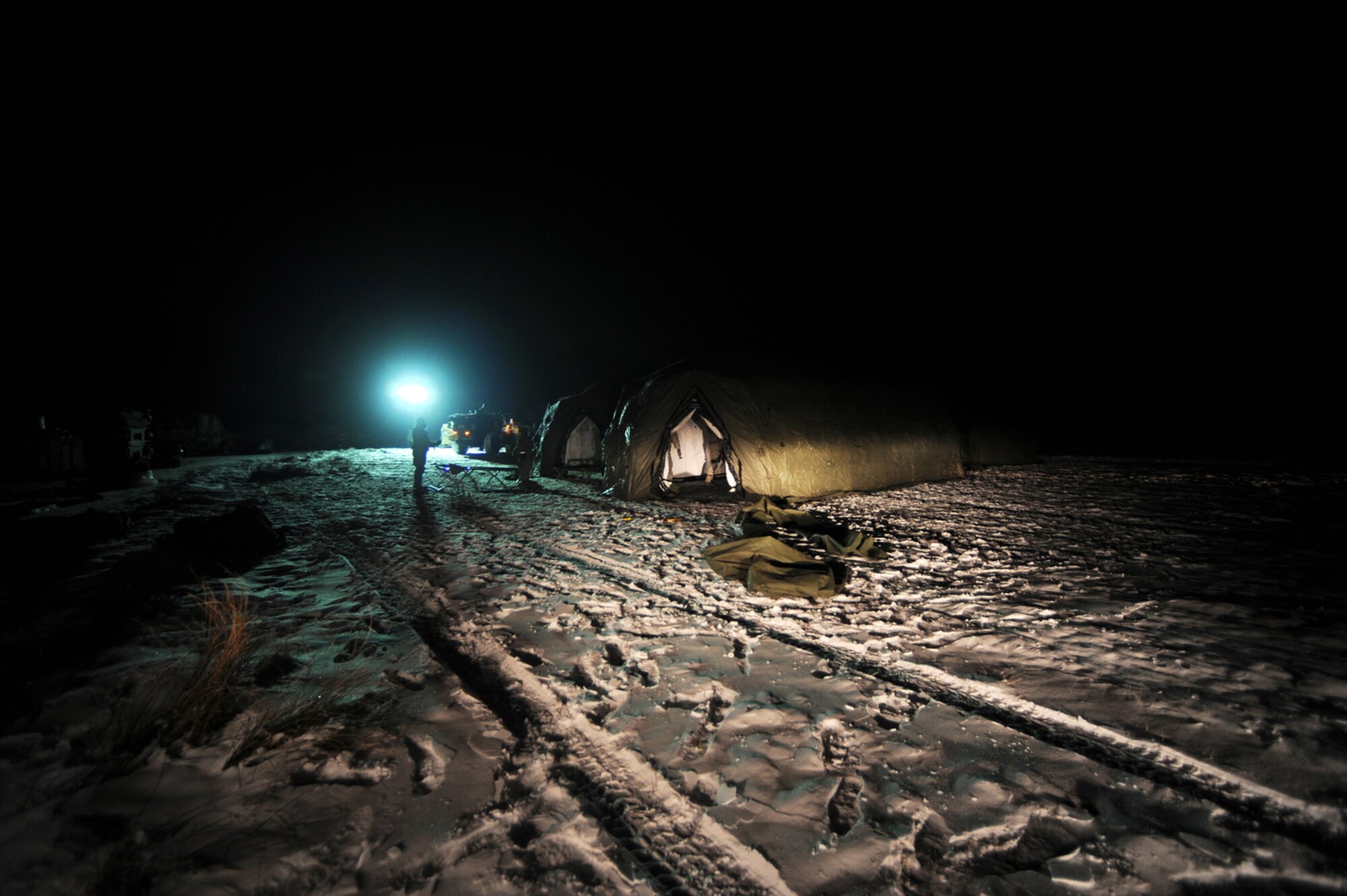 U.S. Air Force members set up tents after their arrival at Flugplatz Bitburg, Germany, Jan. 26, 2010, in preparation of Ramstein's operational readiness inspection in September. The units are setting up bare-base operations as part of the dual-wing operational readiness exercise with the 86th Airlift Wing. This is the second of five operational readiness exercises. (U.S. Air Force photo by Staff Sgt. Sarayuth Pinthong)