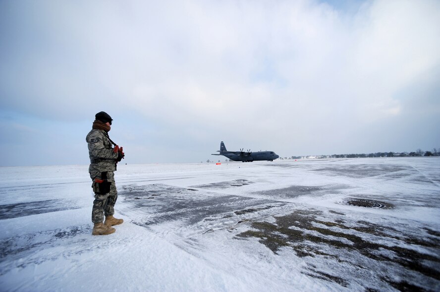 U.S. Air Force Staff Sgt. Justin Gedhardt, 435th Air Mobility Squadron, Ramstein Air Base, Germany, pulls security for a C-130 Hercules as it approaches the parking area at Flugplatz Bitburg, Germany, Jan. 26, 2010, in preparation of Ramstein's operational readiness inspection in September. The units are setting up bare-base operations as part of the dual-wing operational readiness exercise with the 86th Airlift Wing. This is the second of five operational readiness exercises. (U.S. Air Force photo by Staff Sgt. Sarayuth Pinthong)