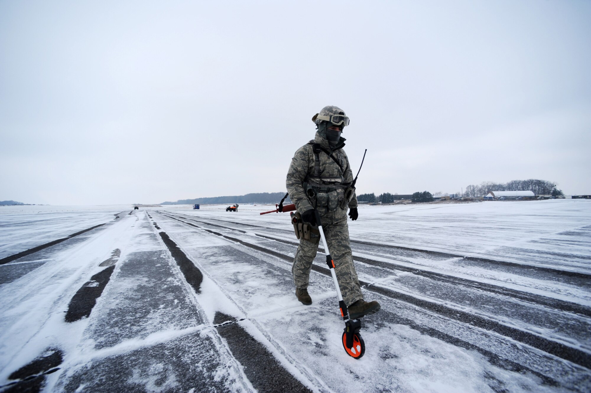 U.S. Air Force Master Sgt. Thomas Franz, 435th Air Mobility Squadron, contingency airfield manager, Ramstein Air Base, Germany, marks off a safe distance to set up reflective markers prior to the landing of C-130 Hercules carrying military members and cargo at Flugplatz Bitburg, Germany, Jan. 26, 2010, in preparation of Ramstein's operational readiness inspection in September. The units are setting up bare-base operations as part of the dual-wing operational readiness exercise with the 86th Airlift Wing. This is the second of five operational readiness exercises. (U.S. Air Force photo by Staff Sgt. Sarayuth Pinthong)