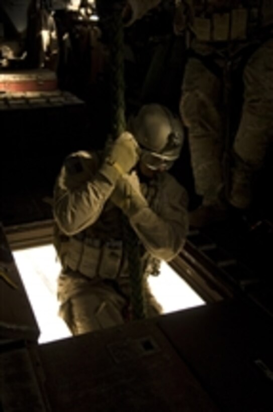 A U.S. Air Force pararescueman begins his descent of 40 feet from the belly of a Marine Corps CH-53E Super Stallion helicopter over the Horn of Africa on Jan. 5, 2010.  The pararescuemen are conducting training on their insertion and extraction techniques.  