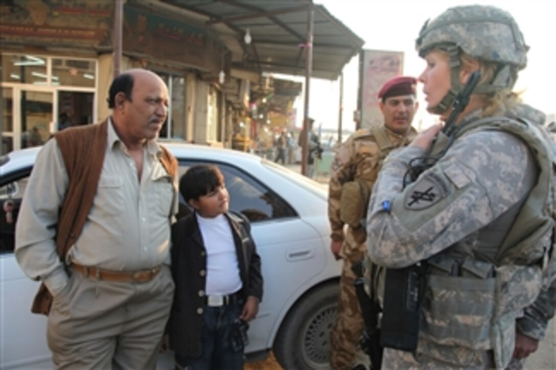 U.S. Army Capt. Jayne Strathe, attached to 1314th Civil Affairs Company, 17th Fires Brigade, speaks with a local man about his community during a joint foot patrol conducted with the 14th Iraqi army division, Al Ashar, Iraq, on Dec. 9, 2009.  The patrol was conducted to promote stability and to assess the needs of the local populace.  
