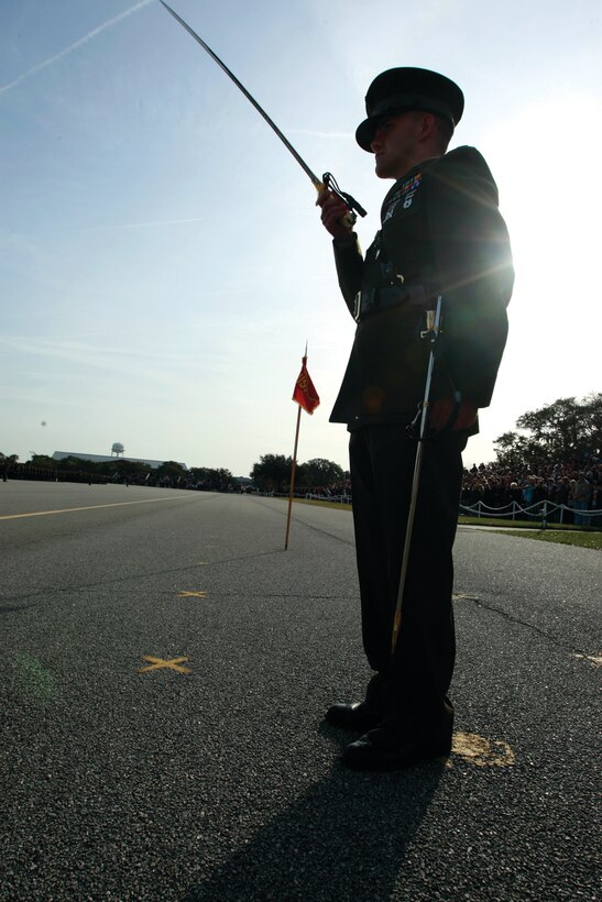 Capt. Casey DeMunck, the Lima Company commander, presents arms as the commander of troops for a graduation ceremony, Jan. 29, at the Peatross Parade Deck.