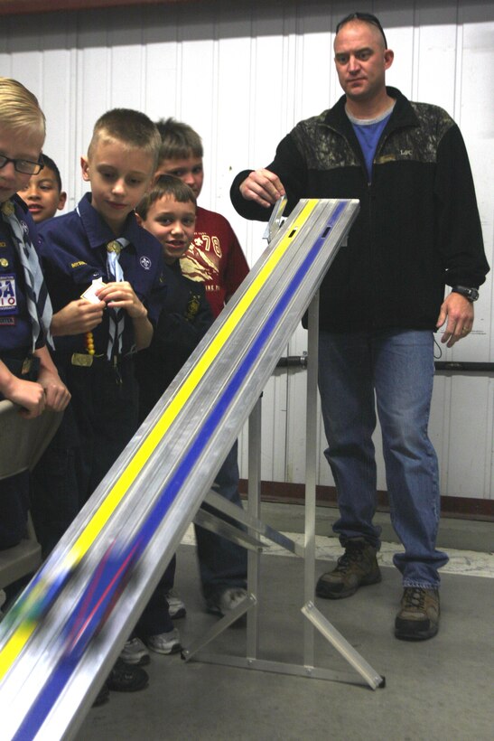 Webelo Scouts with Troop 78, located aboard the Combat Center, watch the cars they built zoom down the track during their annual Pinewood Derby Jan. 30 at their Scout Hut. The scouts and their families built the cars from blocks of wood to race in the event.