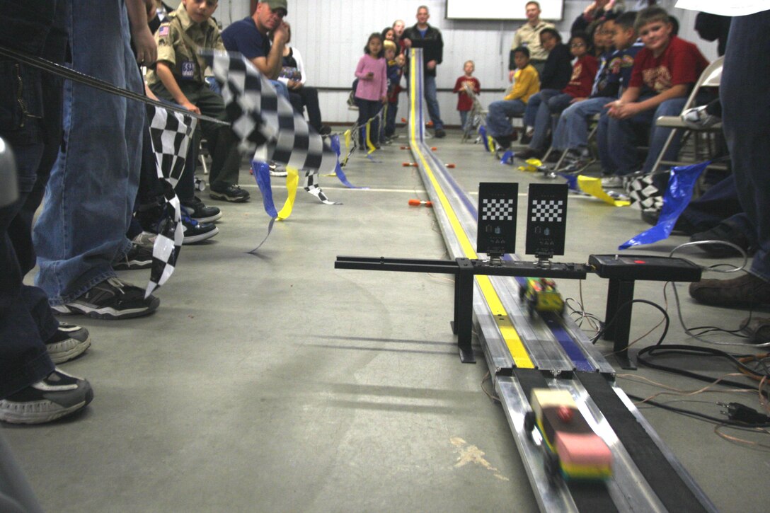 Combat Center Cub Scouts, Webelo Scouts and their families watch as the cars they built zoom down the track during their annual Pinewood Derby Jan. 30 at their Scout Hut. The scouts and their families built the cars from blocks of wood to race in the event.