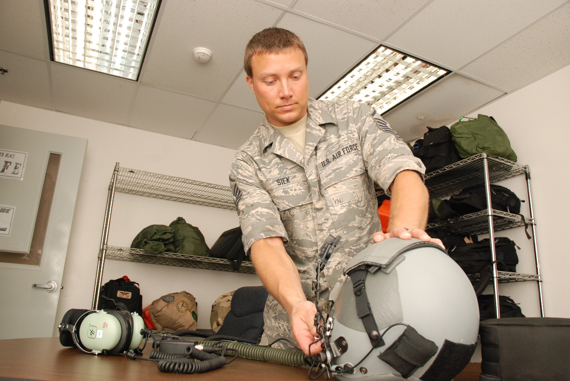 Master Sgt. Aaron Siek, 35th Expeditionary Airlift Squadron life support NCO, performs a pre-flight inspection on an aircrew member's flight helmet.
"For a short time I performed the life support mission by myself during the peak of the airlift missions to Haiti," said Sergeant Siek.  "I came in at all hours within a 24-hour period.  Making sure our aircrews have good safety equipment directly influences and ensures the good work they were doing for the people of Haiti."  (U.S. Air Force photo/Master Sgt. Stan Coleman)
