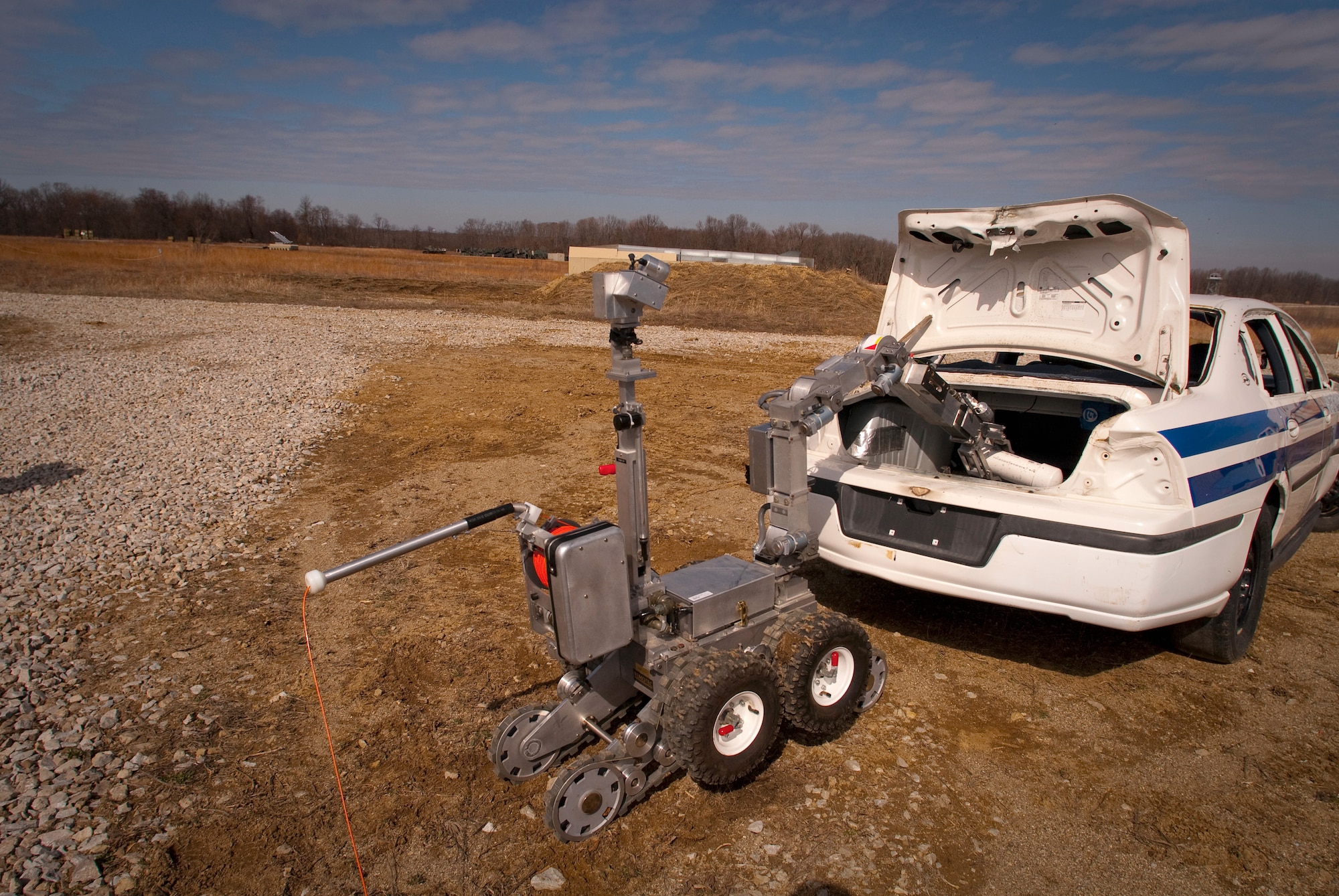 A Remotec MK VI Andros robot, steered remotely by a Kentucky Air National Guard explosive ordnance disposal technician, removes a simulated pipe bomb from a suspicious vehicle during a training evolution at Camp Atterbury, Ind. In addition to clearing the Camp Atterbury Air-to-Ground Gunnery Range for the Indiana National Guard, the Kentucky Airmen were able to get hands-on experience that will sharpen their skills for a variety of real world missions. (U.S. Air Force photo/Tech. Sgt. D. Clare)