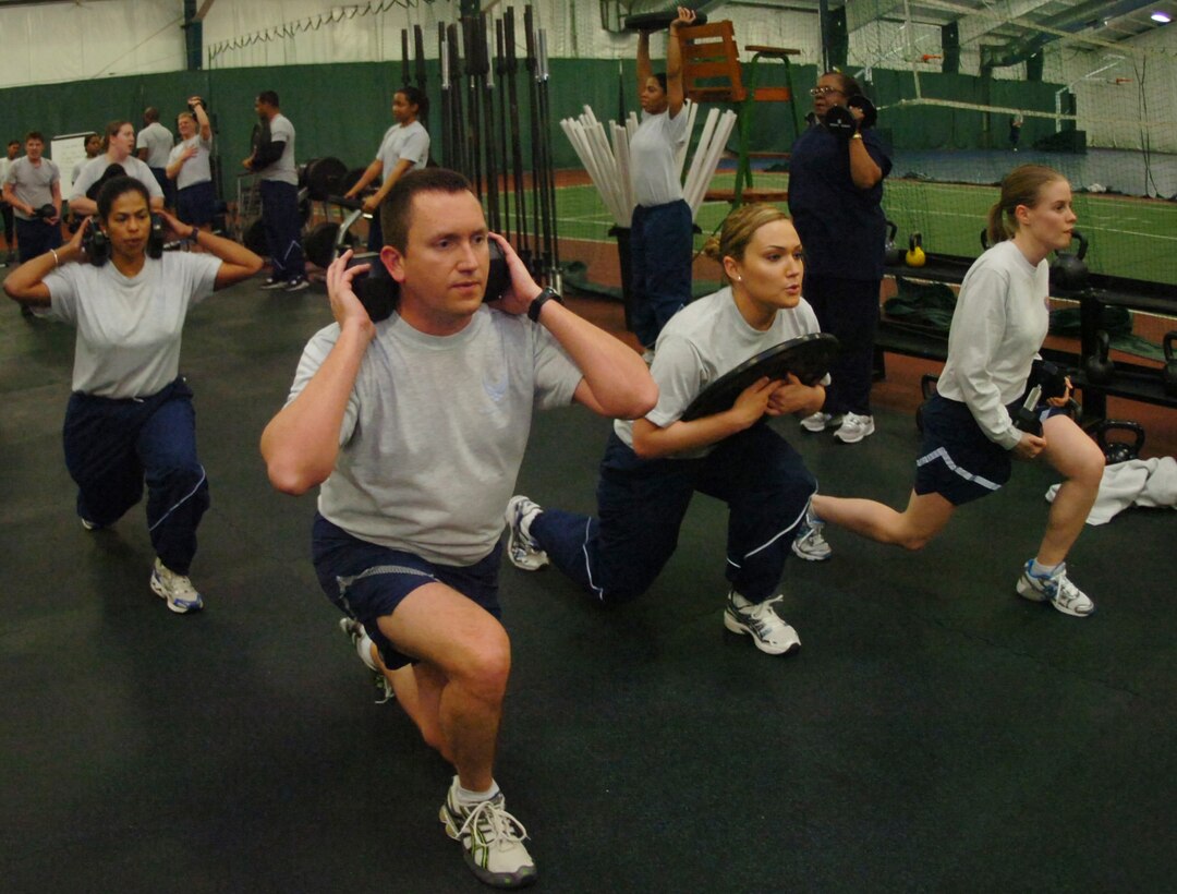 A group of Air Force District of Washington members perform a series of squats with weights during a CrossFit class held at the Tactical Fitness Center room, in the West Fitness Center Jan. 20, 2010. (U.S. Air Force photo by Bobby Jones)