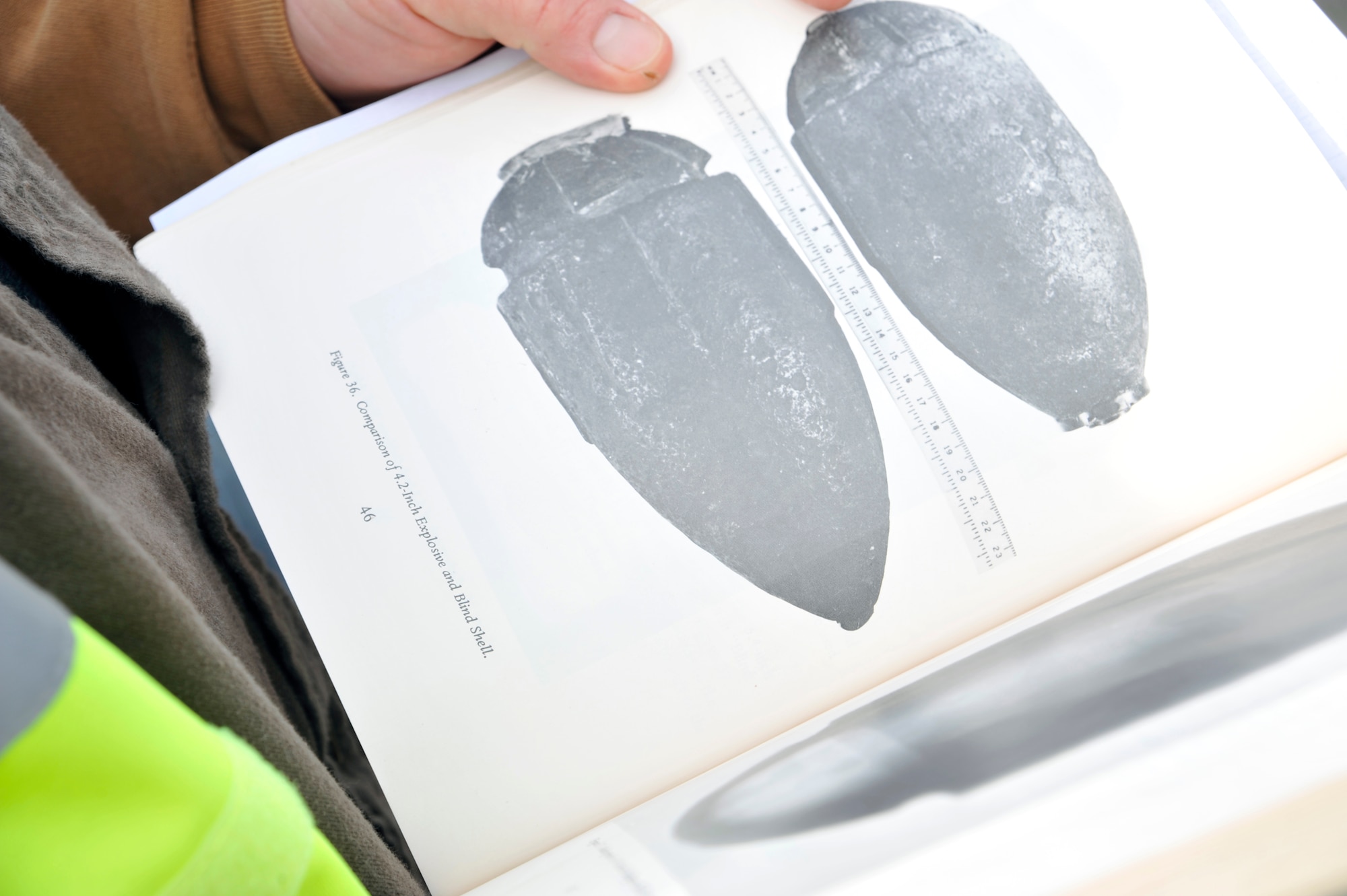A 316th Civil Engineer Squadron explosive ordnance disposal team member looks through a book to identify the type of unexploded ordnance, or UXO, found Jan. 20, 2010. The UXO was a shell from the Civil War era. Andrews EOD respond to any UXO for Joint Bases Andrews, Bolling AFB and Anacostia Naval Air Station, D.C. (U.S. Air Force photo by Airman 1st Class Perry Aston)