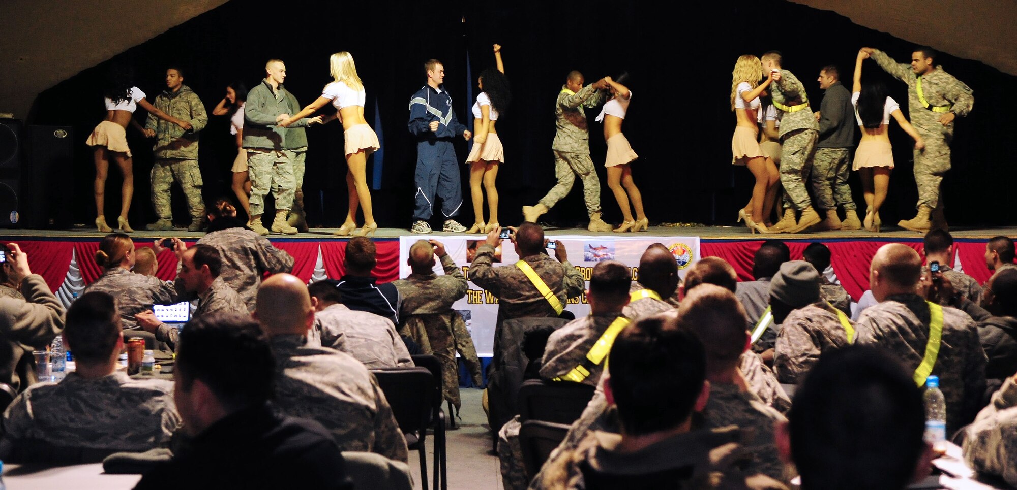 Washington Redskins cheerleaders perform for Airmen, Soldiers, Sailors and Marines deployed or transiting through Transit Center at Manas, Kyrgyzstan, Jan. 28, 2010. The Transit Center is their first stop in a two-week long tour performing for servicemembers deployed to Southwest Asia. (U.S. Air Force photo/Senior Airman Nichelle Anderson/Released)